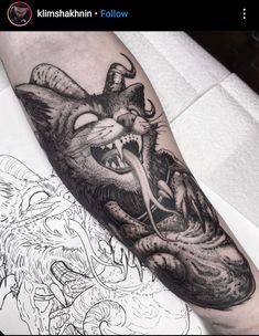 a black and white cat tattoo on the left arm, with an evil looking face