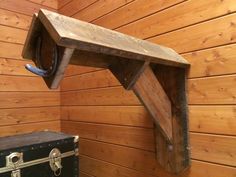 a wooden bench sitting on top of a wooden floor next to a trunk and suitcase