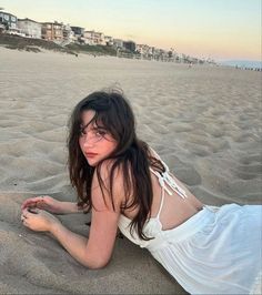 a woman laying on top of a sandy beach