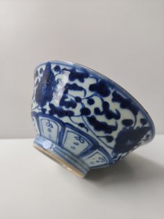 a small blue and white bowl sitting on top of a table next to a wall