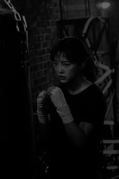 black and white photograph of a woman wearing boxing gloves