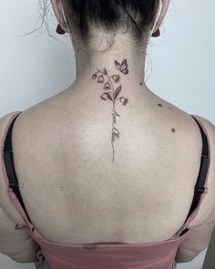 the back of a woman's neck with flowers and butterflies on her left side