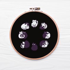 a cross stitch pattern with cats and dogs in the center on a black circle frame