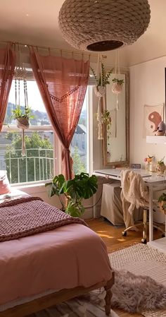 a bedroom with pink bedding and hanging plants