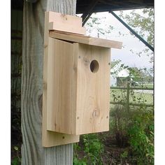 a wooden birdhouse hanging from the side of a tree