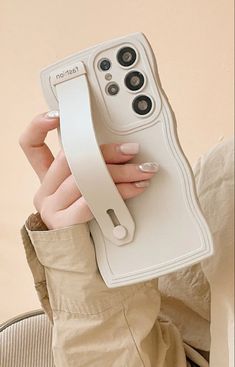 a woman holding up a cell phone case that is shaped to look like an object