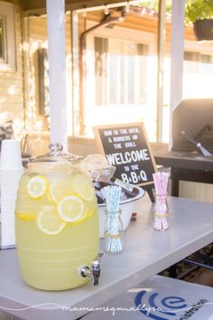 a lemonade drink sitting on top of a table next to a sign that says welcome