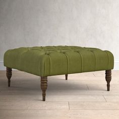 a green bench sitting on top of a hard wood floor next to a white wall