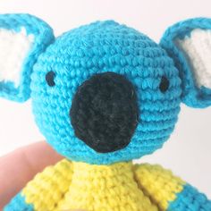 a small crocheted koala bear in a yellow and blue dress is shown