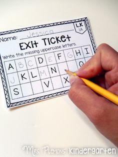 a person holding a pencil and writing on a ticket