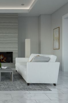 a living room filled with white furniture and a fire place in the middle of it