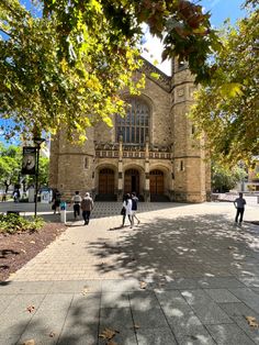 people are walking around in front of an old building