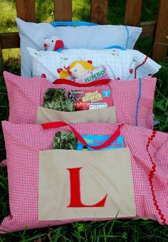 a pile of pillows sitting on top of a grass covered field next to a wooden bench