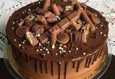 a cake with chocolate frosting and candies on top, sitting on a table