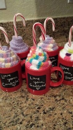 coffee mugs decorated with candy canes and marshmallows