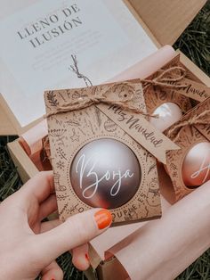 a person holding an open box with two eggs in it and the packaging is wrapped in brown paper