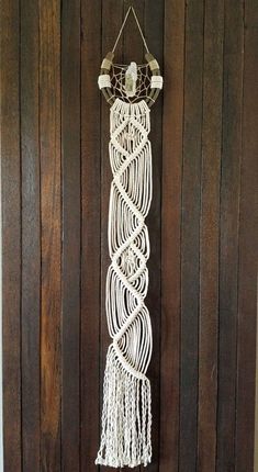 a white macrame hanging on the side of a wooden door