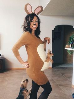 a woman in a bunny costume standing next to a dog