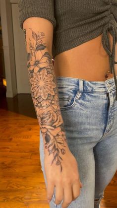 a woman's arm with flowers on it, and the bottom half of her body