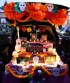 a decorated car trunk with decorations on the hood and in the back, is parked outside