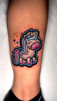 a small tattoo on the leg of a woman's leg with a colorful unicorn