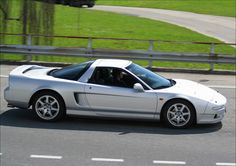 a silver sports car driving down the road