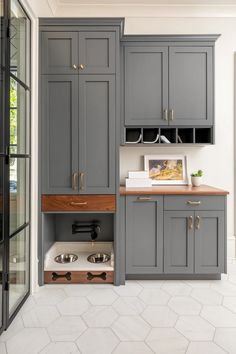 a kitchen with gray cabinets and wooden counter tops