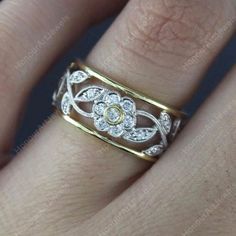 a woman's hand with a gold and diamond ring on it