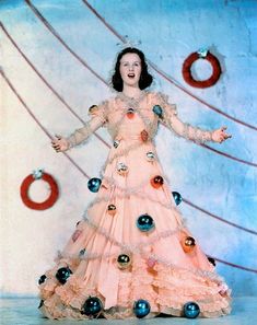 a woman in a pink dress with ornaments around her