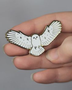 a person holding a white bird pin in their hand