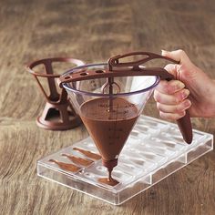 a person is pouring chocolate into a cup