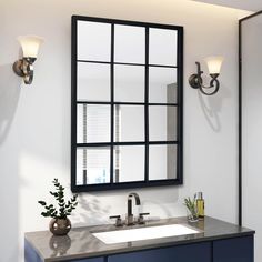 a bathroom sink with a mirror above it and a vase on the counter next to it