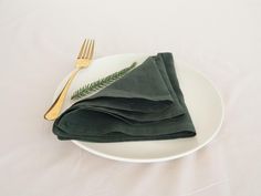 a white plate topped with green napkins next to a fork