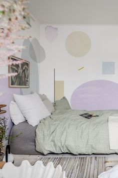 a bed sitting in the middle of a room with lots of pillows on top of it