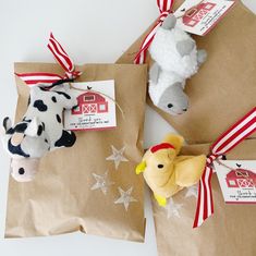 three small stuffed animals tied to brown paper bags