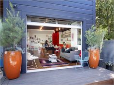 an open garage door with two people sitting on the couches in front of it