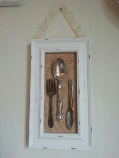 silverware is displayed in a white frame on the wall next to utensils