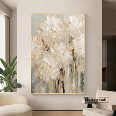 a large white flower painting hanging in a living room