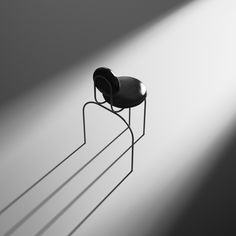 a black chair sitting on top of a metal stand