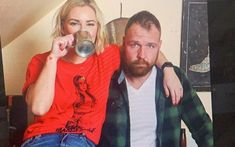 a man and woman sitting next to each other drinking from mugs in their hands