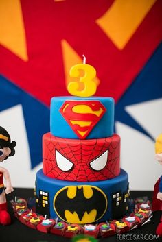 the birthday cake is decorated with batman and spiderman figures