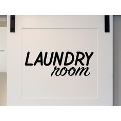 a laundry room sign hanging on the side of a white wall next to a door