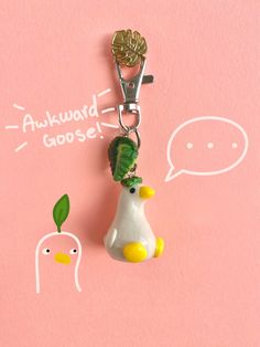 a keychain with a bird on it that says awkward goose next to a duck