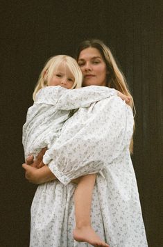 a woman holding a child wrapped in a blanket