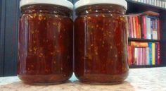 two jars filled with food sitting on top of a table next to a book shelf