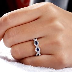 a woman's hand with a diamond and sapphire ring