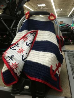 a crocheted blanket sitting on top of a luggage cart