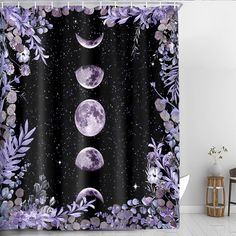 a shower curtain with three phases of the moon and purple flowers in front of it