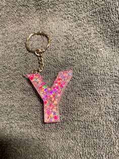 the letter y is made out of glitter and has a keychain attached to it