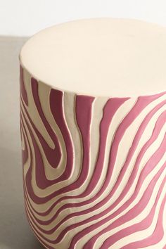 a pink and white vase sitting on top of a table